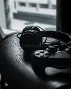 black-aesthetic-wired-headphones-playstation-controller-connected-to-sitting-wooden-chair-dark-moody-196043933.webp
